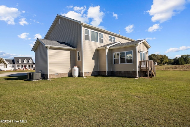 rear view of house featuring a yard and central AC