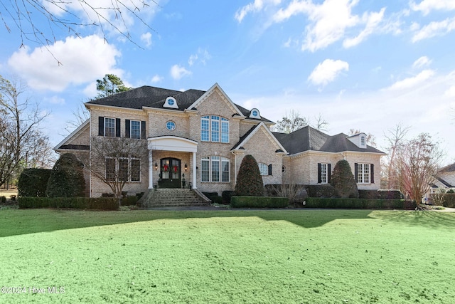 french country home with a front yard and french doors