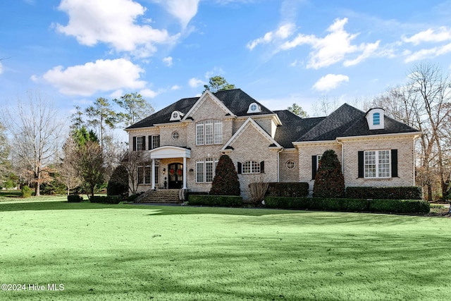 french country inspired facade with a front lawn