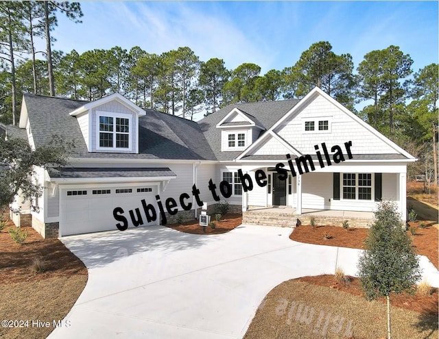 view of front of home with a garage, driveway, a porch, and a shingled roof