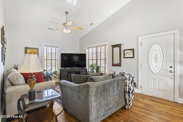 living room with hardwood / wood-style floors, ceiling fan, and high vaulted ceiling