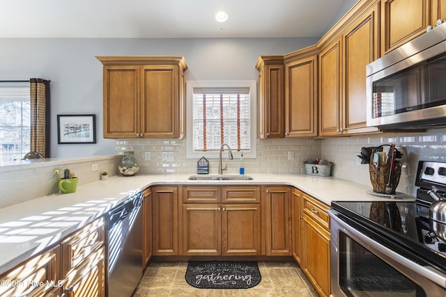 kitchen featuring backsplash, a wealth of natural light, sink, and stainless steel appliances