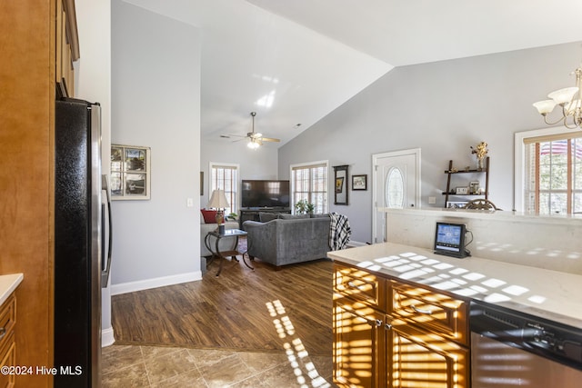 kitchen featuring high vaulted ceiling, dark wood-type flooring, ceiling fan with notable chandelier, and appliances with stainless steel finishes