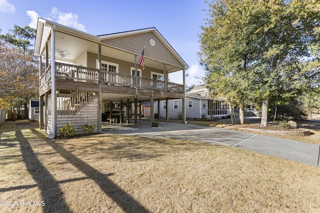 view of front of house with ceiling fan, covered porch, and a carport