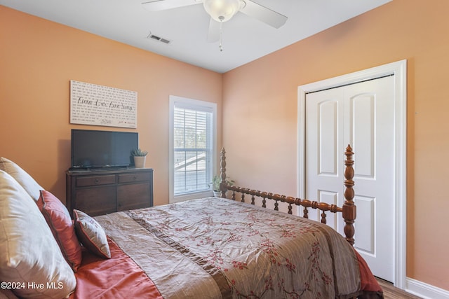 bedroom with a closet, hardwood / wood-style flooring, and ceiling fan