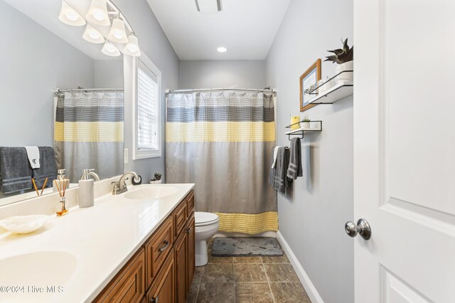 bathroom with a shower with shower curtain, vanity, and toilet