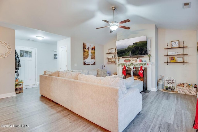 living room with ceiling fan, vaulted ceiling, and hardwood / wood-style flooring