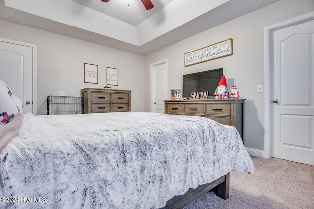 bedroom with carpet, ceiling fan, and a tray ceiling