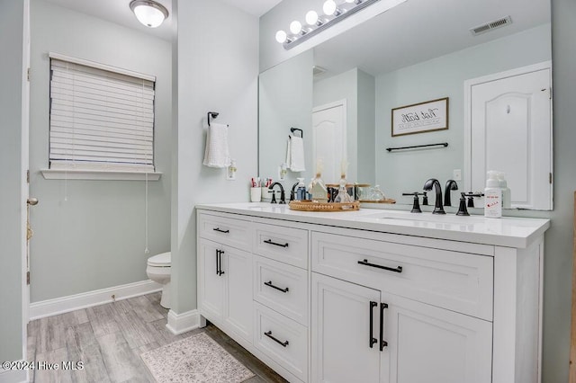 bathroom with hardwood / wood-style flooring, vanity, and toilet