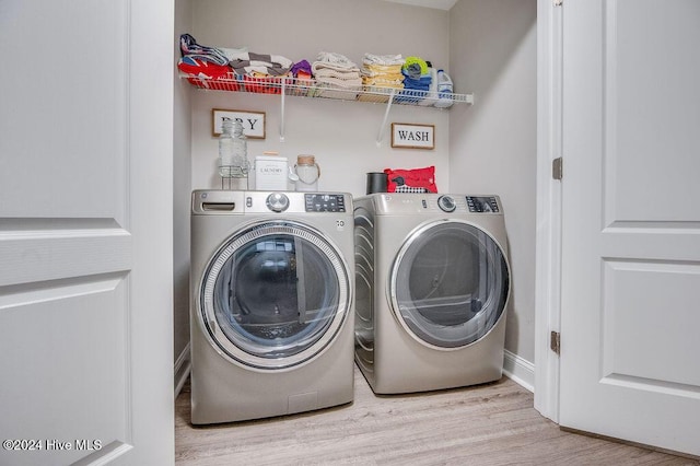 washroom with independent washer and dryer and light wood-type flooring