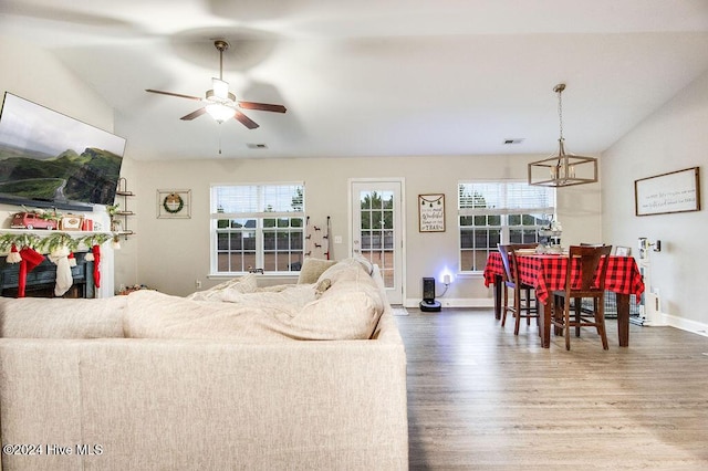 living room featuring hardwood / wood-style flooring, ceiling fan, a wealth of natural light, and vaulted ceiling