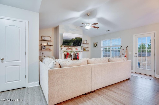 living room featuring hardwood / wood-style floors, ceiling fan, and vaulted ceiling