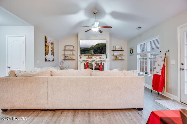 living room with a fireplace, ceiling fan, hardwood / wood-style floors, and lofted ceiling