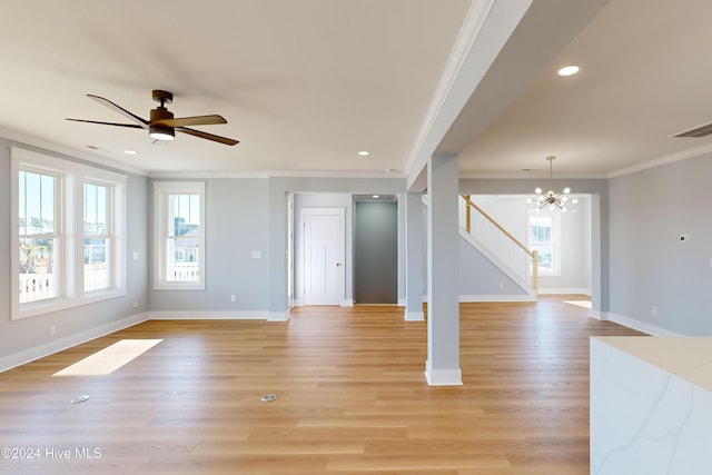 unfurnished living room featuring ceiling fan with notable chandelier, light wood-type flooring, and ornamental molding