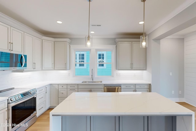 kitchen with tasteful backsplash, light stone counters, pendant lighting, and stainless steel appliances