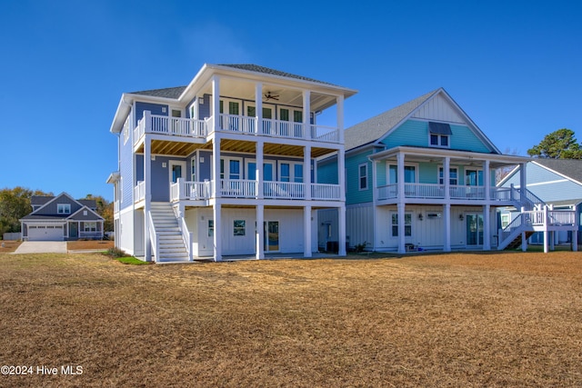 back of property with a lawn, ceiling fan, and a balcony