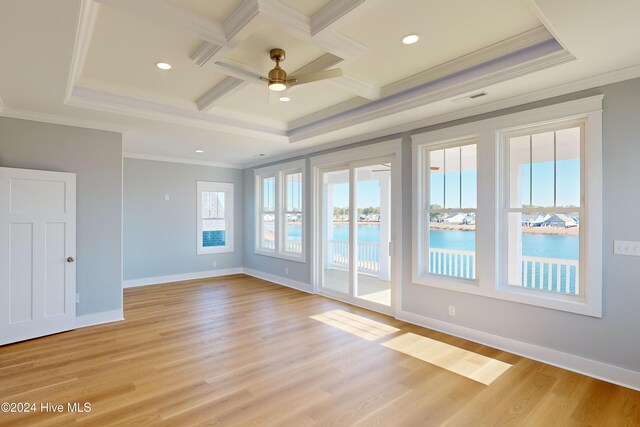 spare room with ceiling fan, a water view, ornamental molding, and light wood-type flooring