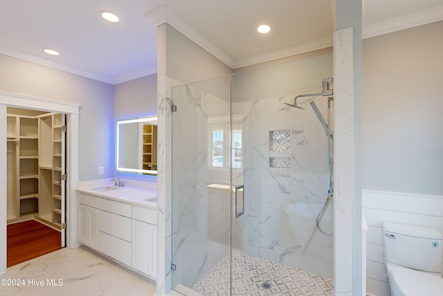 bathroom with vanity, toilet, ornamental molding, and a shower with door