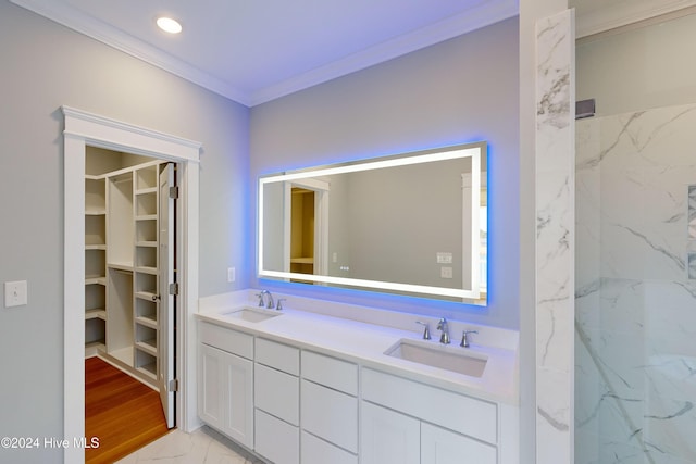 bathroom with hardwood / wood-style floors, vanity, a tile shower, and crown molding