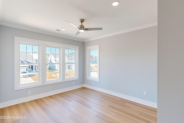 spare room with plenty of natural light, ornamental molding, and light hardwood / wood-style flooring