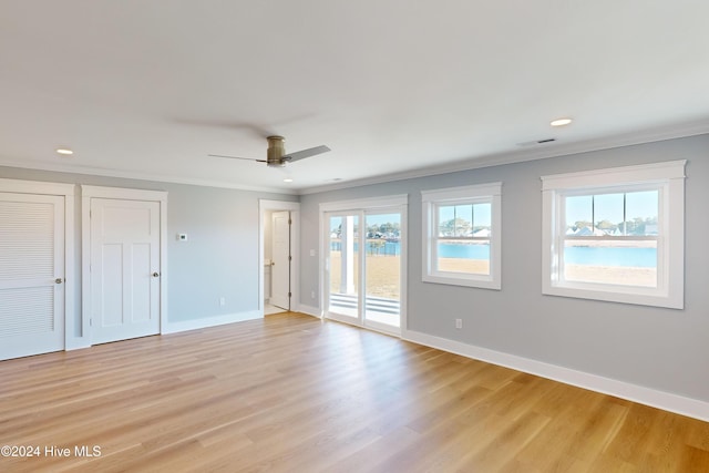 unfurnished room featuring ceiling fan, light wood-type flooring, and ornamental molding