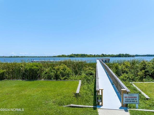 view of home's community featuring a lawn and a water view