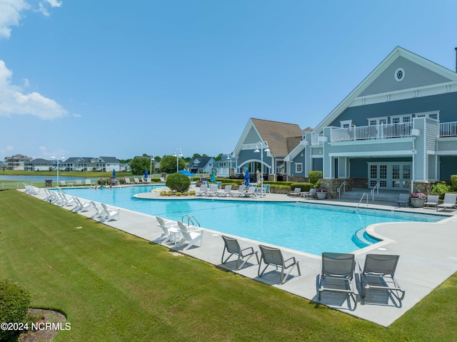 view of pool with a lawn, a patio, and french doors