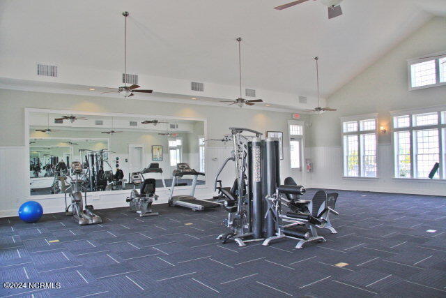 workout area with dark carpet and high vaulted ceiling