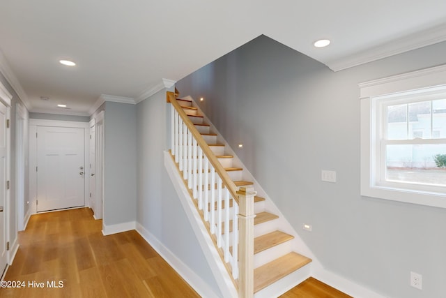 stairway featuring hardwood / wood-style flooring and crown molding