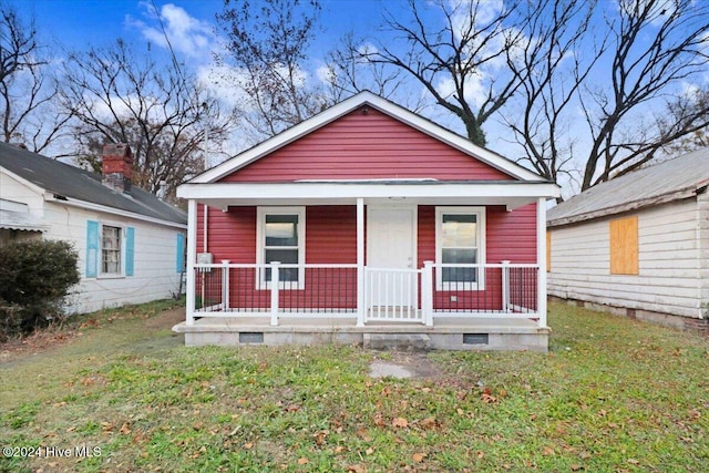 bungalow with a front lawn and covered porch