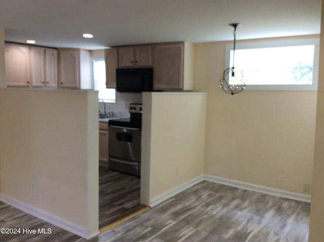 kitchen featuring hardwood / wood-style flooring, sink, stainless steel electric range oven, and hanging light fixtures