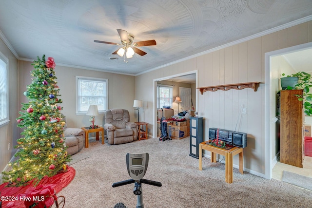 interior space with carpet flooring, ceiling fan, and ornamental molding