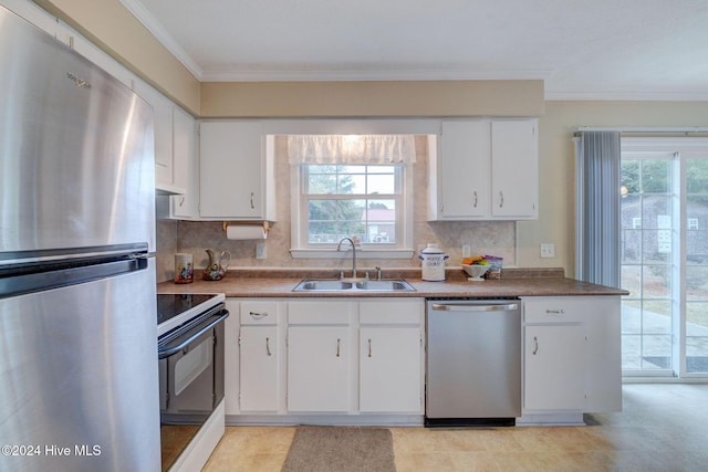 kitchen with stainless steel appliances, white cabinetry, a healthy amount of sunlight, and sink