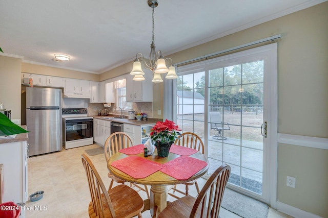 dining space with crown molding, sink, and an inviting chandelier