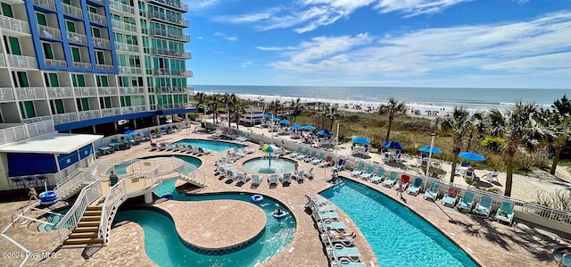 view of pool with a water view and a view of the beach