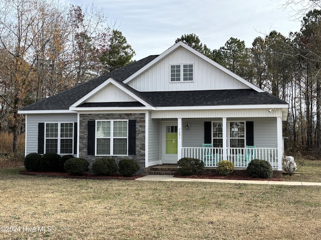 view of front of home with a porch and a front yard