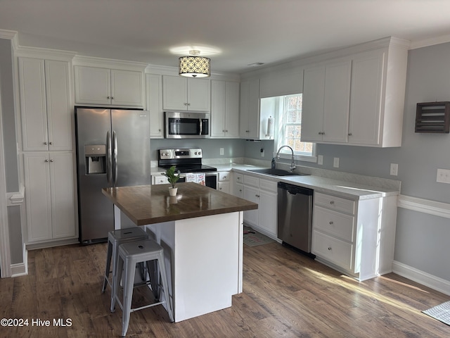 kitchen featuring appliances with stainless steel finishes, dark wood-style flooring, white cabinetry, and a sink