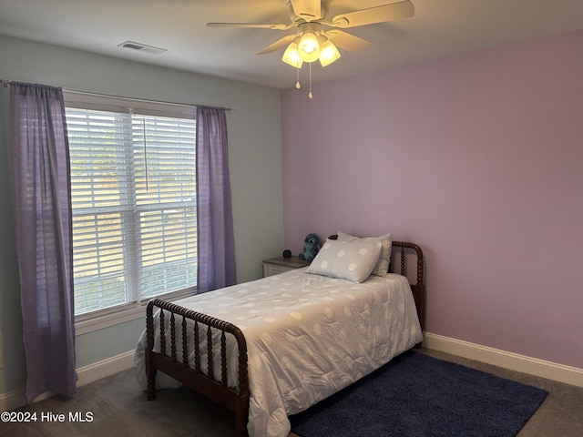 carpeted bedroom with multiple windows and ceiling fan