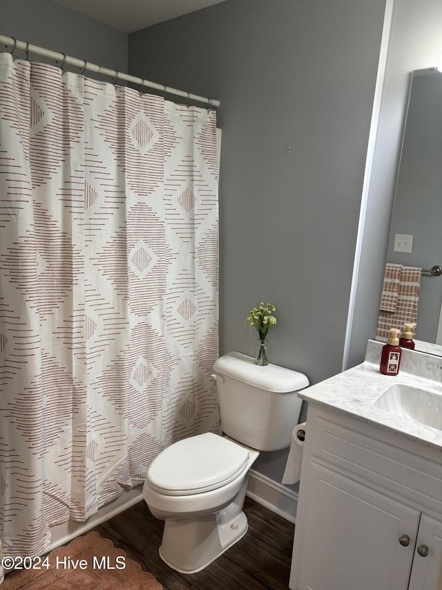 bathroom with toilet, vanity, a shower with curtain, and wood finished floors