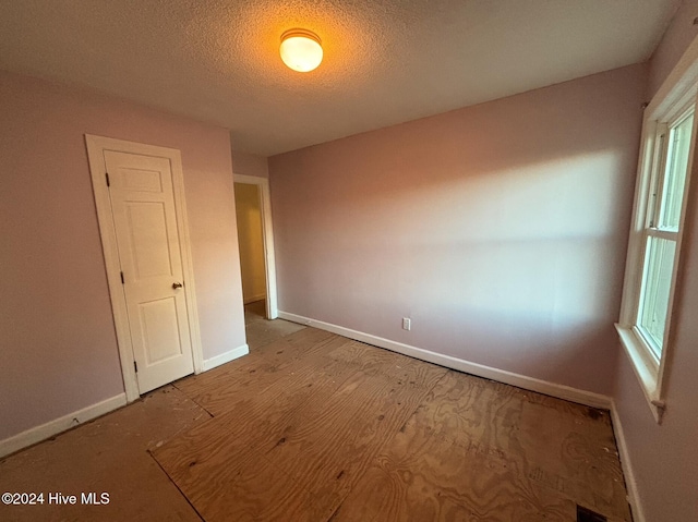 empty room featuring a healthy amount of sunlight and a textured ceiling