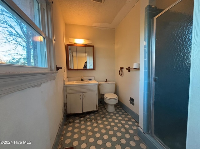 bathroom featuring vanity, an enclosed shower, a textured ceiling, and toilet