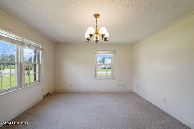 carpeted empty room with a chandelier, a textured ceiling, and a wealth of natural light