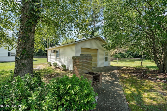 view of home's exterior with an outbuilding, a garage, and a lawn