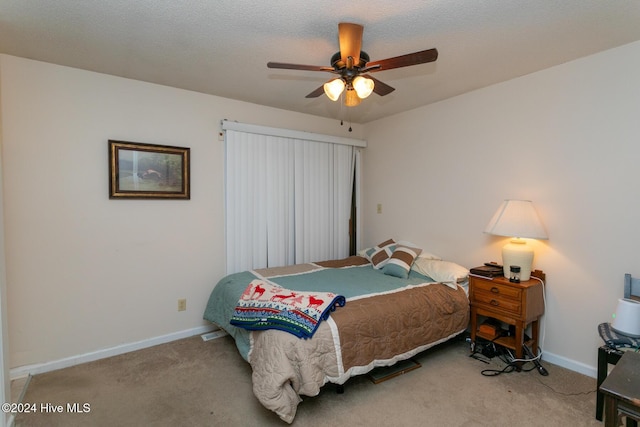 bedroom featuring carpet flooring, ceiling fan, and a textured ceiling