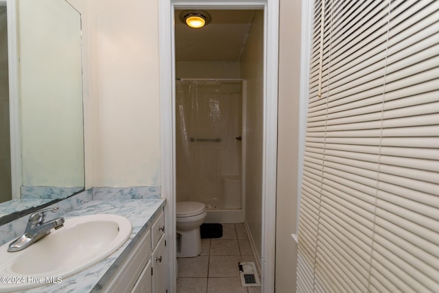 bathroom with tile patterned floors, vanity, toilet, and walk in shower