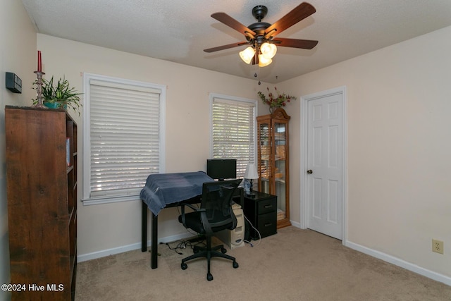 office space with light carpet, a textured ceiling, and ceiling fan