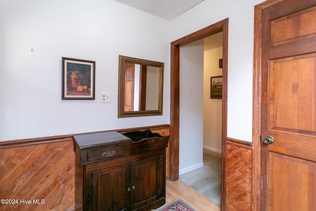 hallway with a textured ceiling and light hardwood / wood-style floors