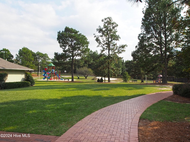 view of home's community featuring a playground and a yard