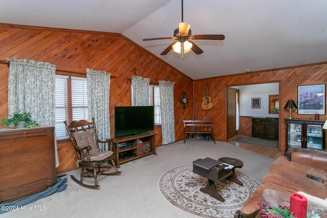 living room featuring wooden walls, ceiling fan, and lofted ceiling