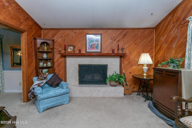 carpeted living room with wood walls, lofted ceiling, crown molding, a textured ceiling, and a fireplace